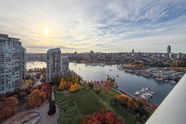 Spacious 2-bedroom condo with stunning city and marina views, featuring a balcony with vibrant fall foliage.