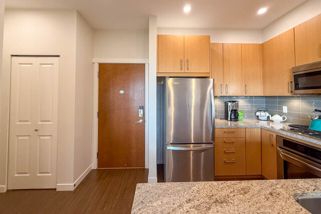 Bright kitchen with granite countertops, hardwood floors, and stainless steel appliances. - 526-119 West 22nd Street, North Vancouver