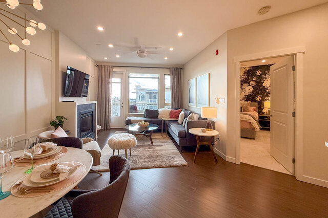 Spacious living room with hardwood floors, modern decor, and a cozy fireplace. - 526-119 West 22nd Street, North Vancouver