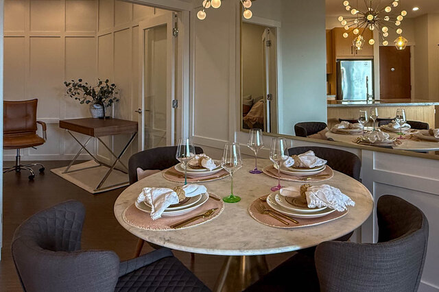 Elegant dining area with marble table, modern chairs, and a view into the kitchen. - 526-119 West 22nd Street, North Vancouver