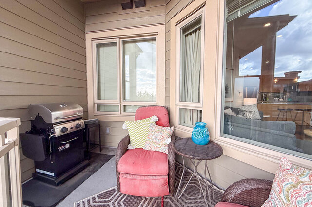 Cozy balcony with a grill, plush pink chairs, and a city view. - 526-119 West 22nd Street, North Vancouver