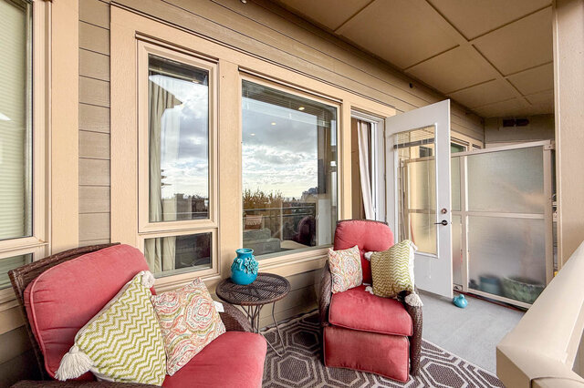 Spacious balcony with cozy seating, city view, and patterned rug. - 526-119 West 22nd Street, North Vancouver