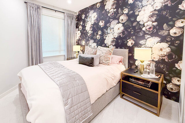 Spacious bedroom with floral wallpaper, cozy bed, and modern nightstands. - 526-119 West 22nd Street, North Vancouver
