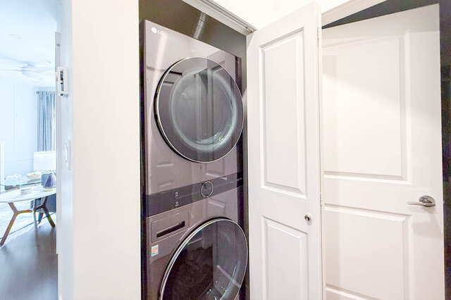 Bright laundry room with LG washer and dryer, white cabinetry, and modern design. - 526-119 West 22nd Street, North Vancouver
