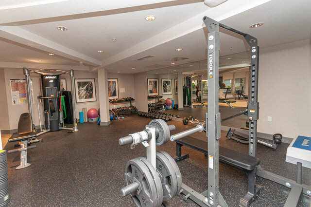 Spacious gym with weightlifting equipment and mirrors, perfect for fitness enthusiasts. - 526-119 West 22nd Street, North Vancouver