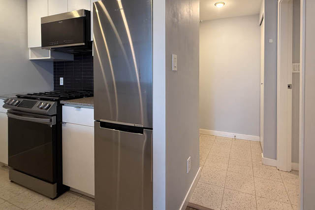 Bright kitchen with stainless steel appliances, granite countertops, and a modern design. - 1011- 939 Expo Blvd., Vancouver Downtown