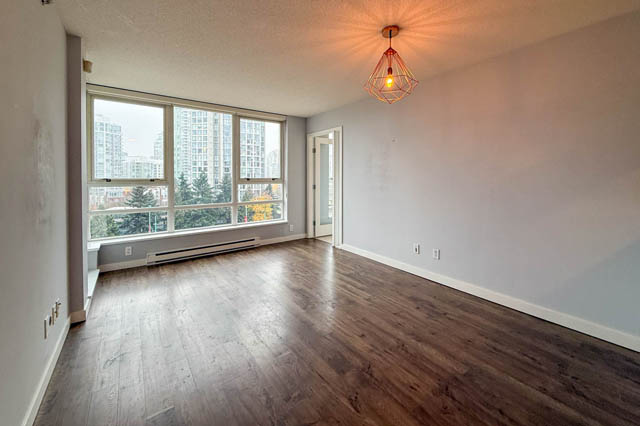 Spacious den with hardwood floors, large windows offering a city view, and a modern light fixture. - 1011- 939 Expo Blvd., Vancouver Downtown