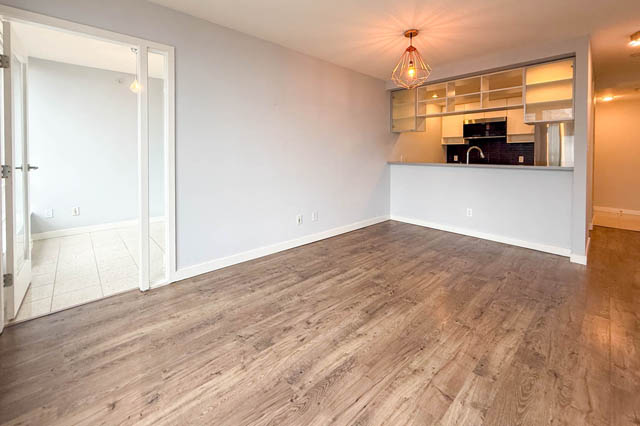 Open-concept living space with hardwood floors and a modern kitchen counter. - 1011- 939 Expo Blvd., Vancouver Downtown