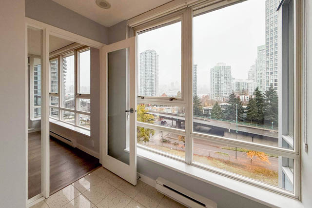 Bright living room with large windows showcasing a city view and modern furnishings. - 1011- 939 Expo Blvd., Vancouver Downtown