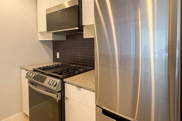 Bright kitchen with granite countertops, stainless steel appliances, and a modern backsplash. - 1011- 939 Expo Blvd., Vancouver Downtown
