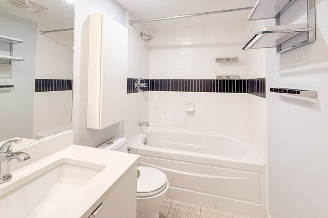 Spacious bathroom with white vanity, bathtub, and shower, featuring sleek fixtures and modern decor. - 1011- 939 Expo Blvd., Vancouver Downtown