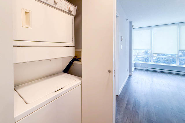 Bright laundry room with white appliances and hardwood floors, leading to a den with a city view. - 1011- 939 Expo Blvd., Vancouver Downtown