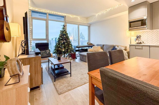 Cozy living room with hardwood floors, a Christmas tree, and a city view. - 407-2435 Kingsway, Vancouver East Side