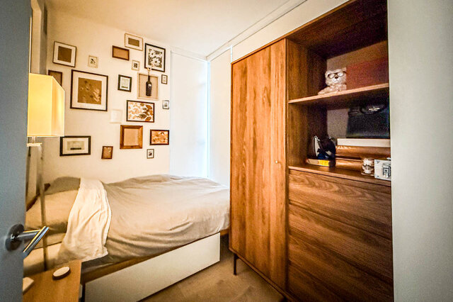 Spacious 1-bedroom + den with cozy wood paneling and a gallery wall of framed art. - 407-2435 Kingsway, Vancouver East Side