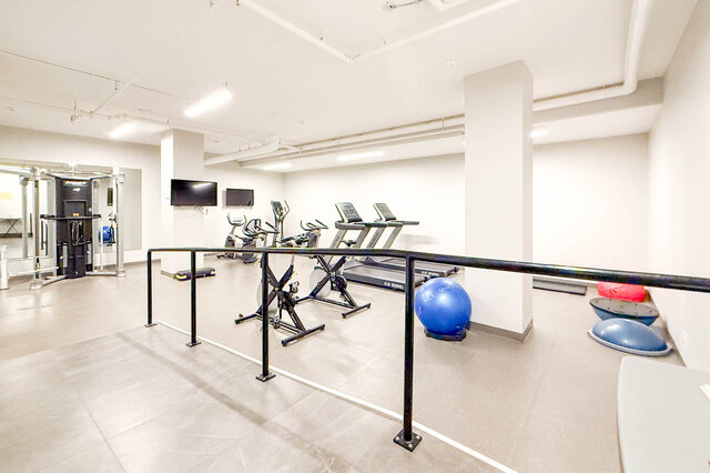 Spacious gym with cardio machines, exercise balls, and a bar for support. - 407-2435 Kingsway, Vancouver East Side
