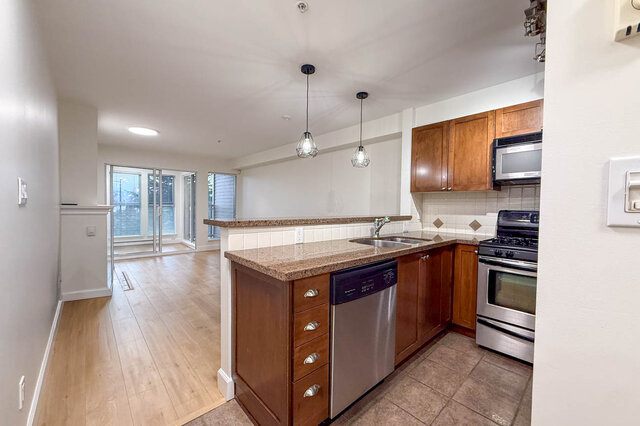 Bright kitchen with granite countertops, hardwood floors, and a view of the city. - 304-3637 West 17th Ave, Vancouver West Side