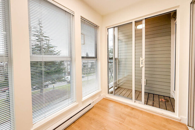 Spacious living room with hardwood floors and large windows offering a city view. - 304-3637 West 17th Ave, Vancouver West Side