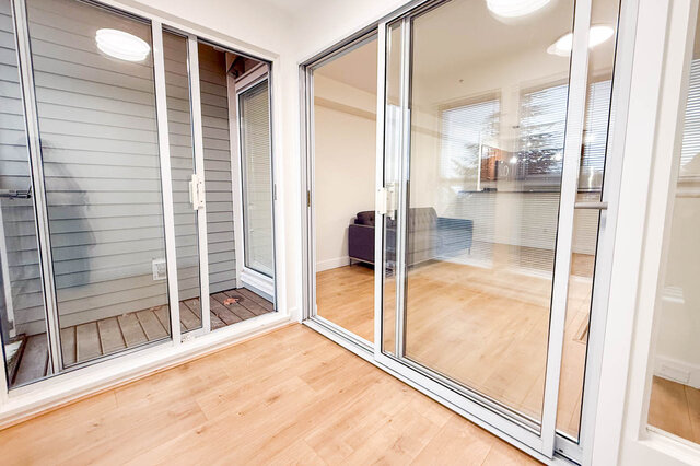 Spacious living room with hardwood floors and sliding glass doors leading to a private patio. - 304-3637 West 17th Ave, Vancouver West Side
