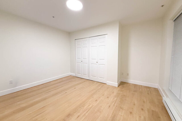 Spacious den with white walls, hardwood floors, and built-in closet. - 304-3637 West 17th Ave, Vancouver West Side