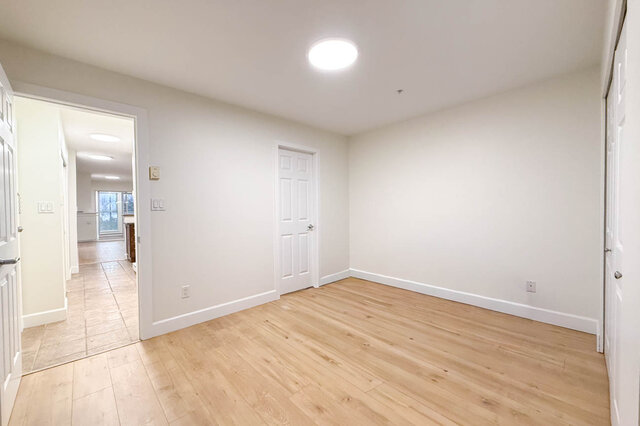 Spacious den with hardwood floors and a white door leading to another room. - 304-3637 West 17th Ave, Vancouver West Side