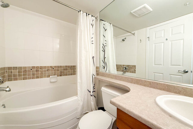 Spacious bathroom with a large bathtub, granite countertops, and a double sink. - 304-3637 West 17th Ave, Vancouver West Side