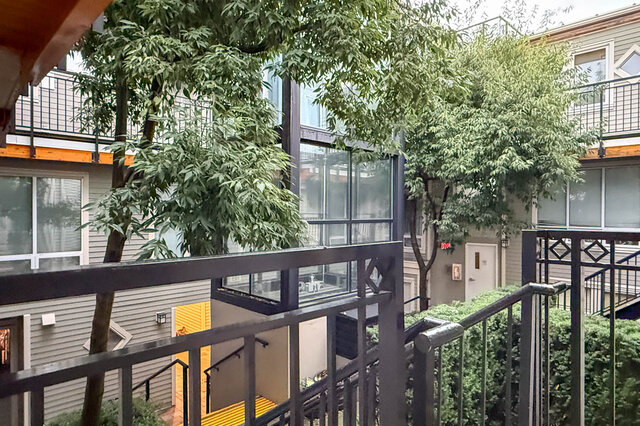 Balcony with lush greenery and modern railings, offering a serene outdoor space. - 304-3637 West 17th Ave, Vancouver West Side