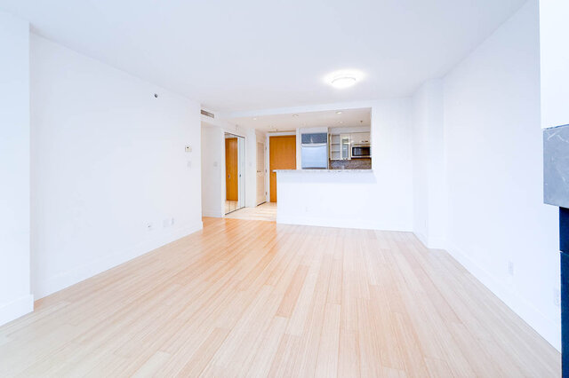 Spacious open-concept living room with hardwood floors and a view into the kitchen. - 706-499 Broughton, Vancouver Downtown