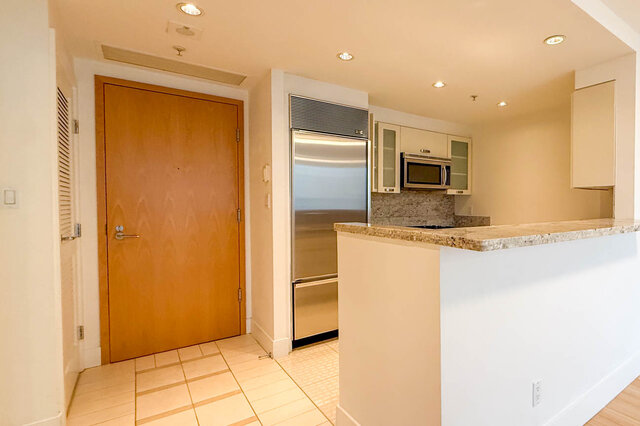 Modern kitchen with granite countertops and stainless steel appliances, perfect for a cozy downtown condo. - 706-499 Broughton, Vancouver Downtown