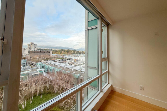 Bright living room with large windows offering a stunning city view and marina, featuring hardwood floors. - 706-499 Broughton, Vancouver Downtown