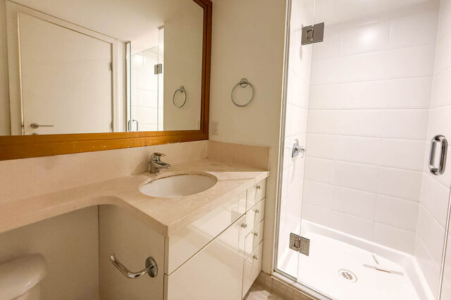 Spacious bathroom with white tile, modern sink, and large mirror. - 706-499 Broughton, Vancouver Downtown