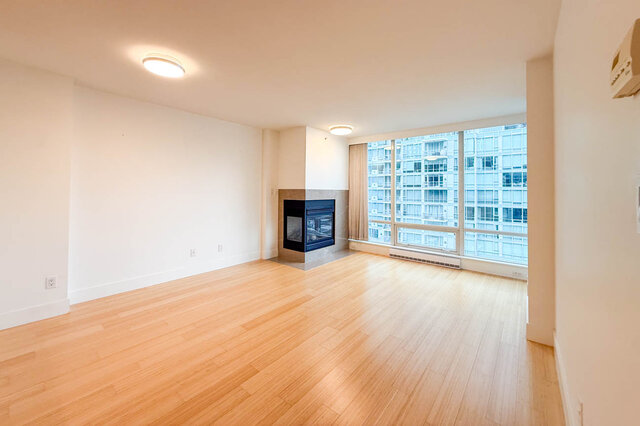 Spacious living room with hardwood floors, a fireplace, and a city view. - 706-499 Broughton, Vancouver Downtown