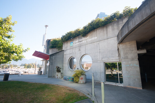 Modern 2-bedroom condo with a concrete facade and large circular windows, offering a unique urban vibe. - 706-499 Broughton, Vancouver Downtown