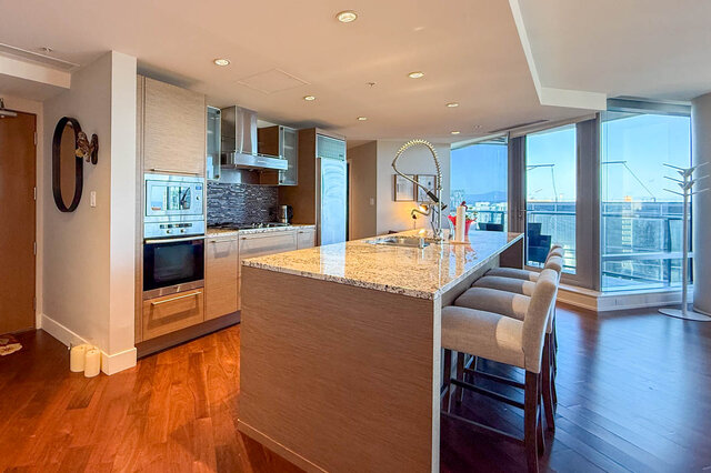 Bright kitchen with granite countertops, hardwood floors, and city views through large windows. - 3309-1111 Alberni Street, Vancouver Downtown