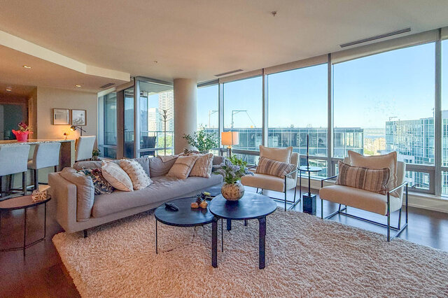 Bright living room with panoramic city views and plush beige sectional sofa. - 3309-1111 Alberni Street, Vancouver Downtown