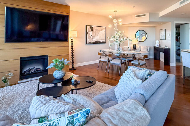 Living room with modern fireplace and hardwood floors in downtown condo. - 3309-1111 Alberni Street, Vancouver Downtown