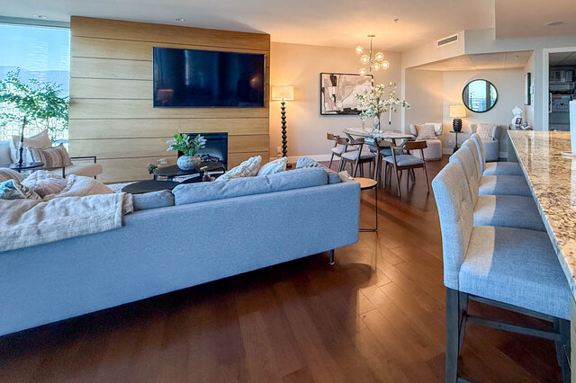 Modern living area with sleek hardwood floors and a cozy blue sectional. - 3309-1111 Alberni Street, Vancouver Downtown