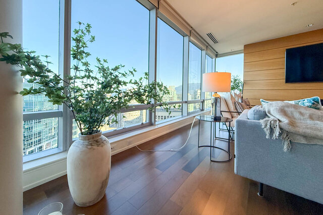 Living room with panoramic city views and rich hardwood flooring. - 3309-1111 Alberni Street, Vancouver Downtown