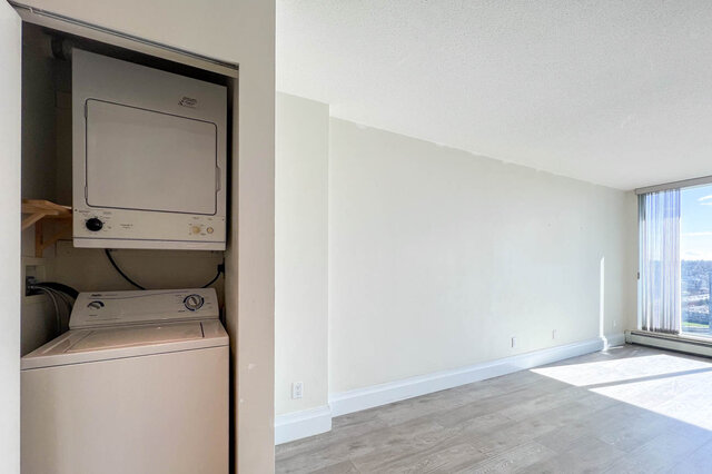 Spacious living room with hardwood floors, city view, and built-in washer and dryer. - 2905-1009 Expo Boulevard, Vancouver Downtown