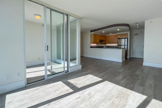 Spacious open-concept living room with hardwood floors and sliding glass doors leading to a patio. - 2905-1009 Expo Boulevard, Vancouver Downtown