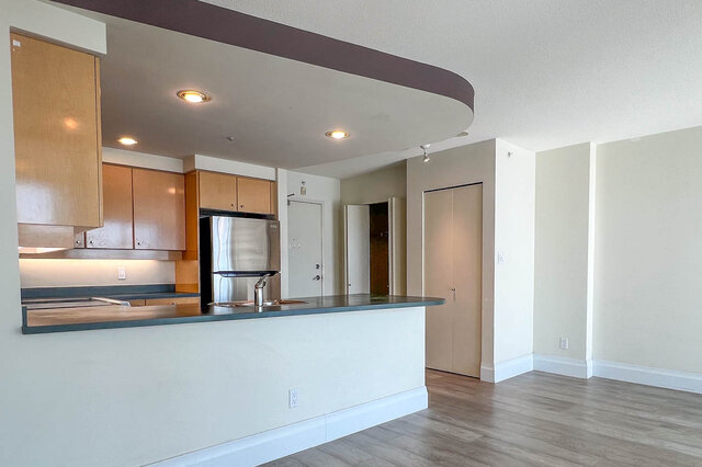 Open-concept living space with modern kitchen featuring granite countertops and hardwood floors. - 2905-1009 Expo Boulevard, Vancouver Downtown
