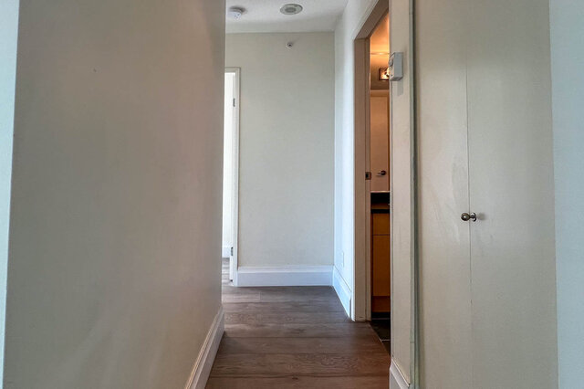 Furnished hallway with hardwood floors and a partially open door leading to another room. - 2905-1009 Expo Boulevard, Vancouver Downtown