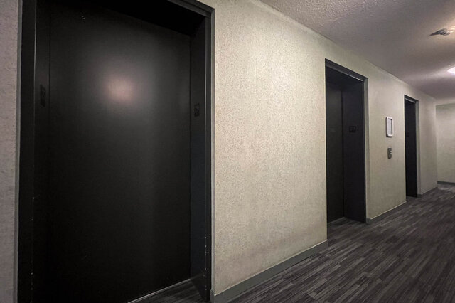 Spacious hallway with dark doors and textured walls, leading to a cozy 2-bedroom + den condo. - 2905-1009 Expo Boulevard, Vancouver Downtown