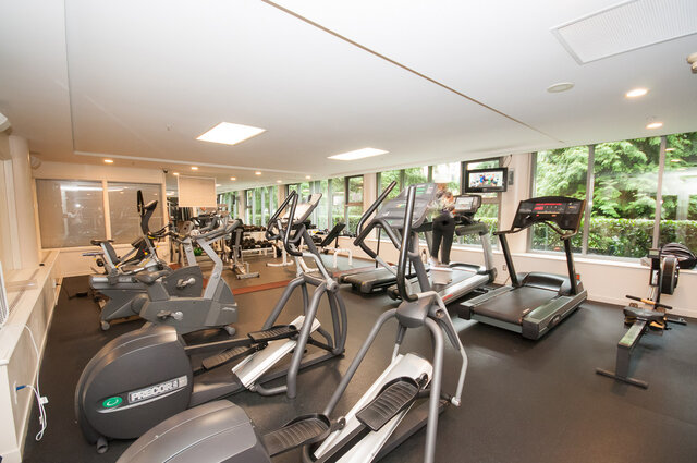 Spacious, well-lit gym with cardio machines and large windows offering a serene view. - 2905-1009 Expo Boulevard, Vancouver Downtown