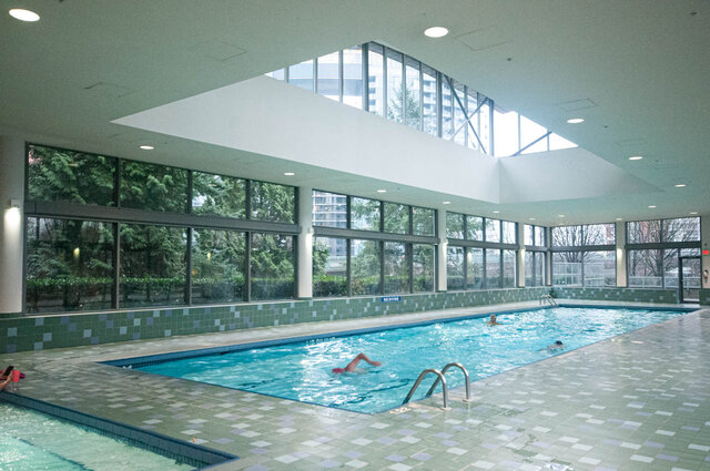 Spacious living room with large windows and a modern indoor pool area. - 2905-1009 Expo Boulevard, Vancouver Downtown