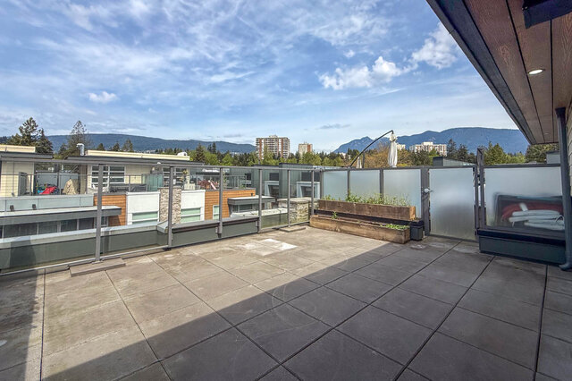 Bright living room with hardwood floors and large windows. - 210-2060 Curling Road, North Vancouver