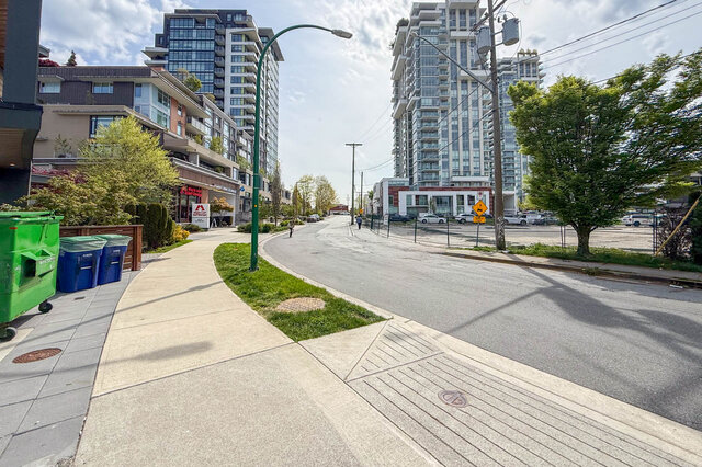 Modern kitchen with white cabinetry, stainless steel appliances, and a gas stove. - 210-2060 Curling Road, North Vancouver