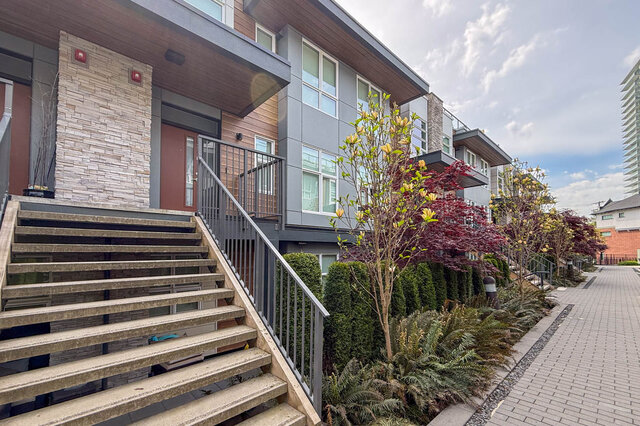Spacious bedroom with hardwood floors and a large window offering a city view. - 210-2060 Curling Road, North Vancouver