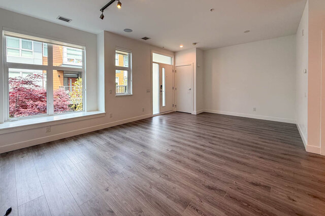 Furnished 2-bedroom townhouse with modern kitchen, hardwood floors, and a cozy living area. - 210-2060 Curling Road, North Vancouver