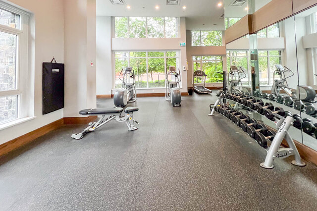 Gym featuring dumbbell rack and expansive windows with lush outdoor views. - 309-2738 Library Lane, North Vancouver