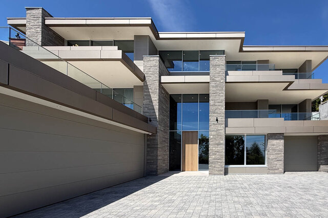 Modern front entrance with stone columns and large glass doors. - 2390 Westhill Drive, West Vancouver